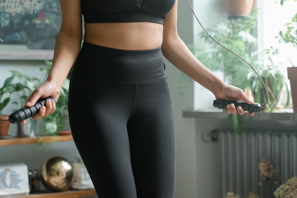 A woman working out inside with a jump rope, promoting fitness and activity.