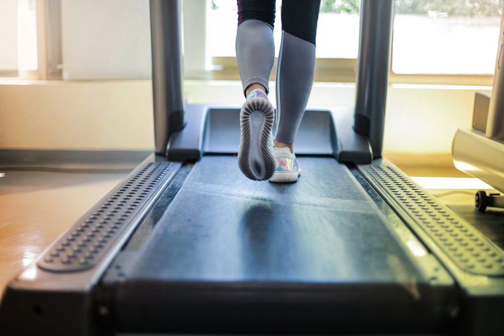 Close-up shot of a person exercising on a treadmill, showcasing fitness and health focus.