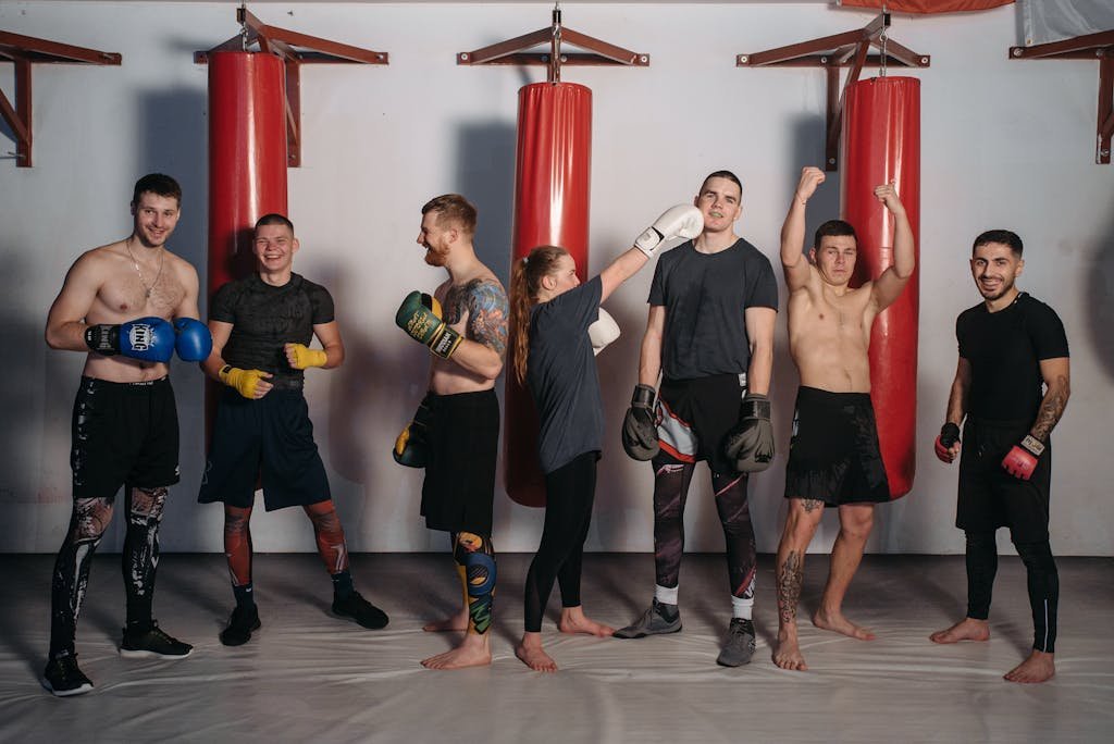 Diverse group of fighters posing in a boxing gym showcasing strength and camaraderie.