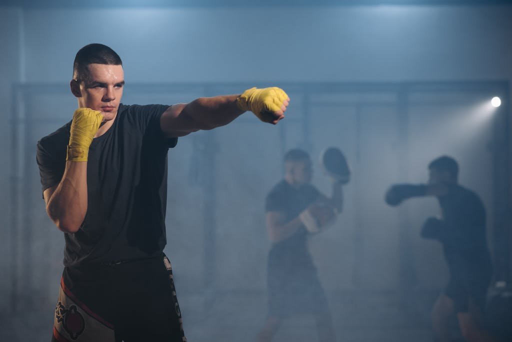 Focused fighters practicing boxing techniques with yellow gloves in a training gym.