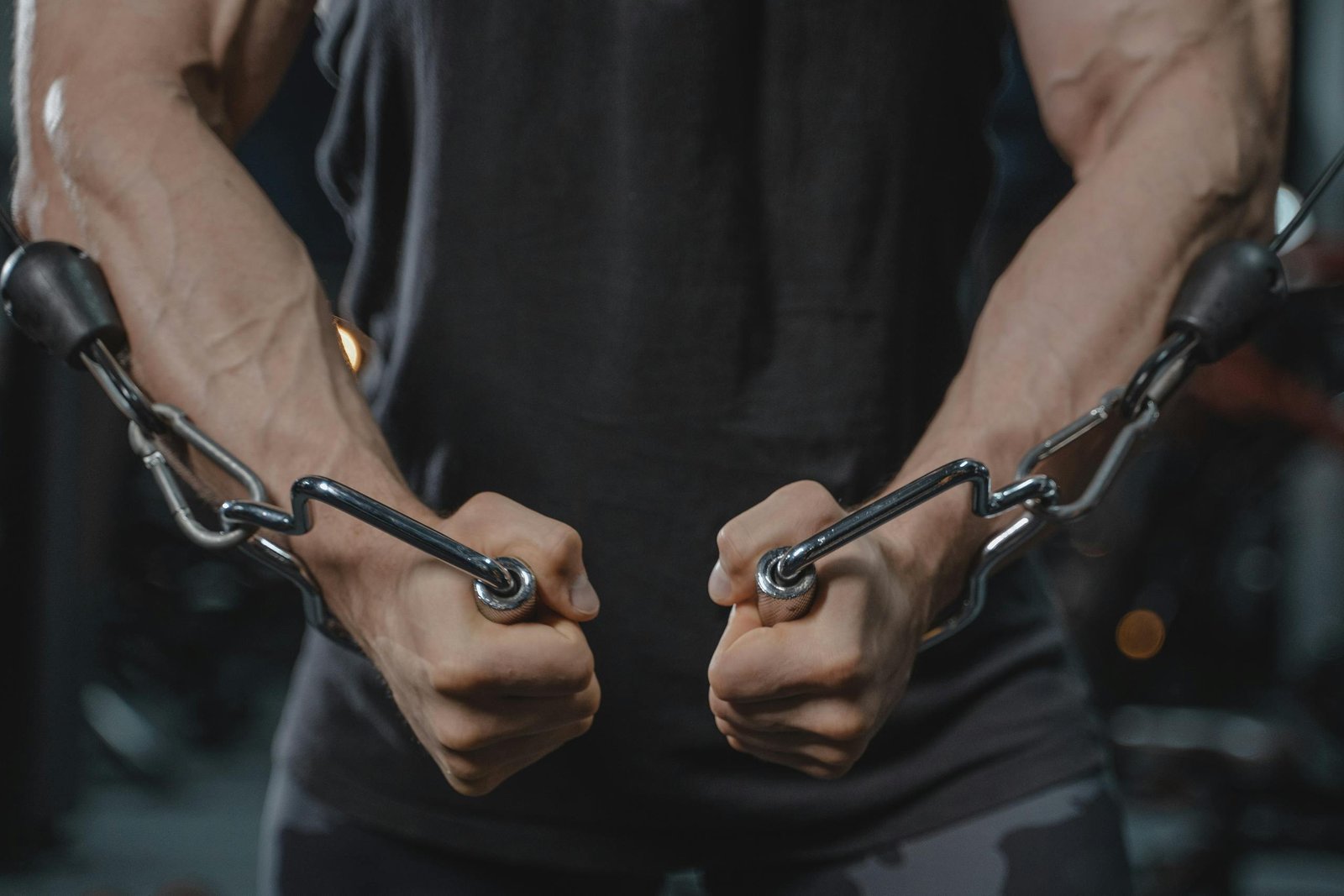 A muscular man exercising with a cable machine, emphasizing strength and fitness.