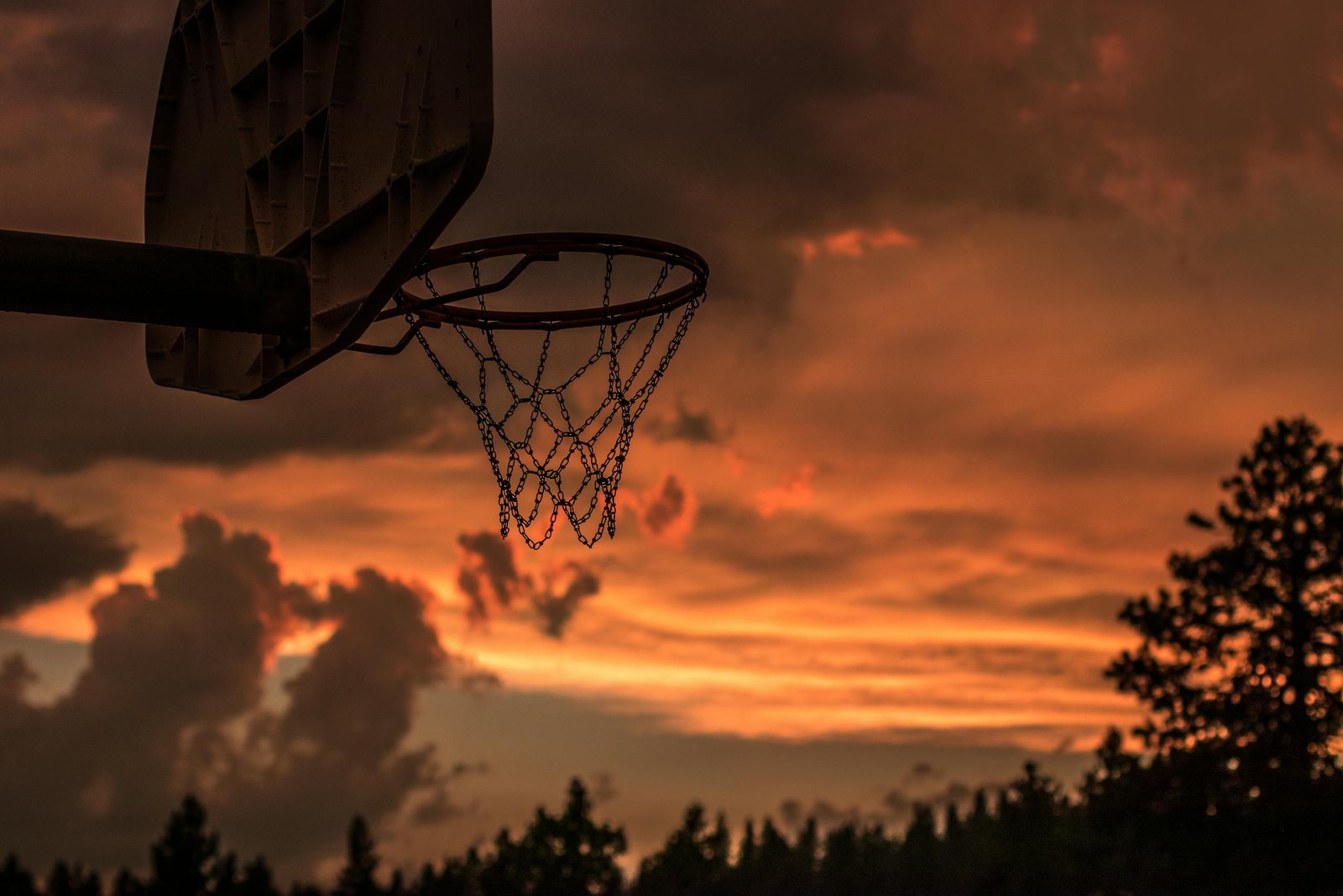 Silhouette of a basketball hoop with vibrant sunset sky in Truckee, CA.